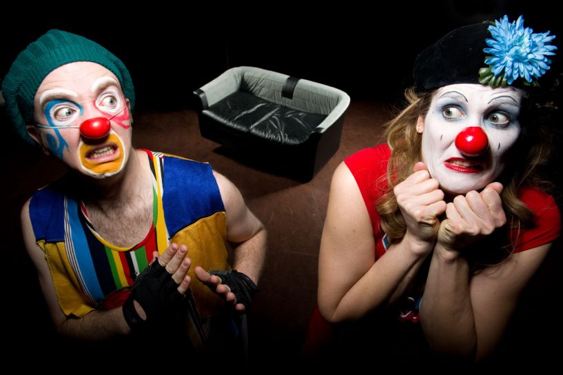 Two clowns afraid of a sofa